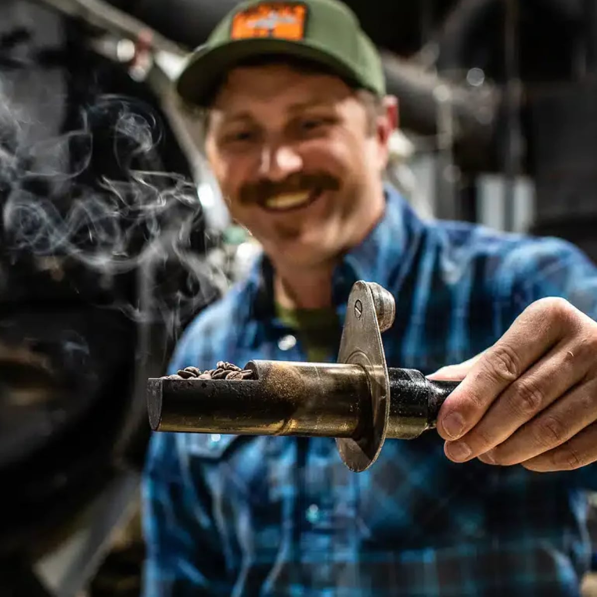 Black Rifle Coffee roaster sampling fresh-roasted beans, steam rising